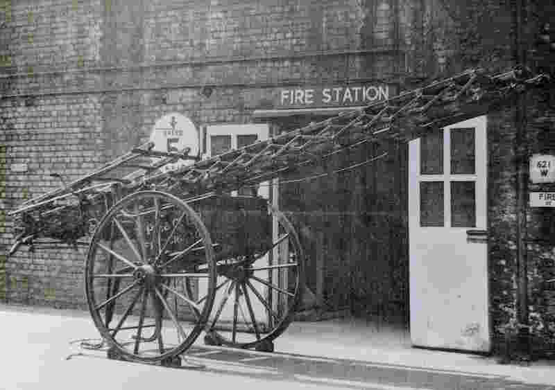 The Peek Frean wheeled fire escape ladder outside of the Peek Frean Fire Brigade station, in around the 1950s. The length of ladder is not extended in the image.