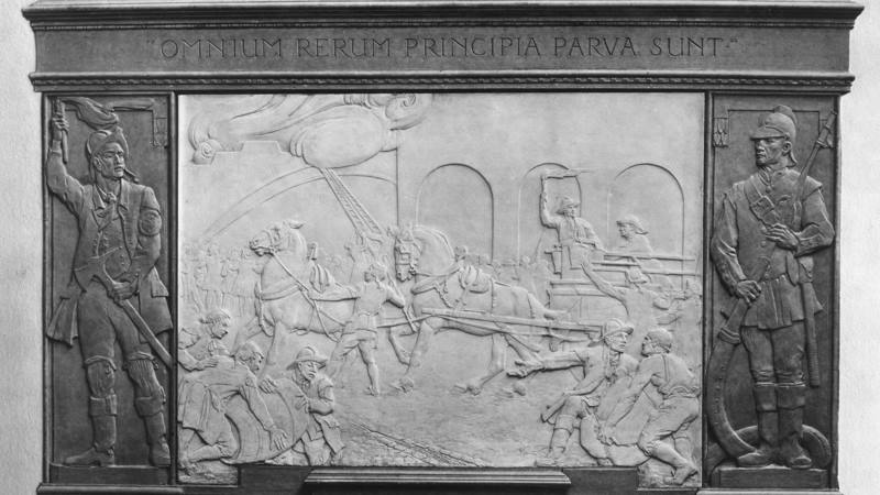 A memorial sculpture featuring firefighters on horse drawn carts