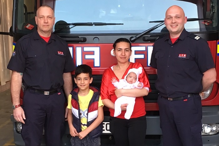 Tottenham Firefighters pose with a mother and her two children in front of a fire engine 