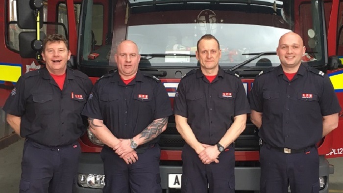 Firefighters standing in front of a fire engine 