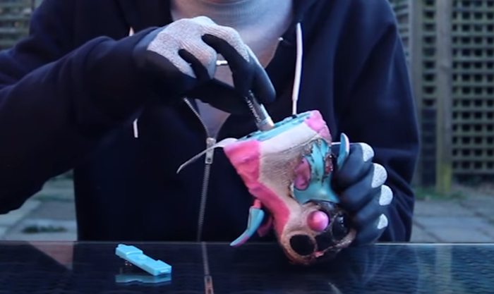 Youtuber holding a battery and toy before burning it 