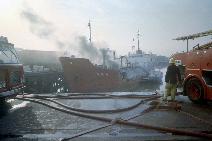 Limehouse basin boat on fire, firefighter and fire engine in the foreground 