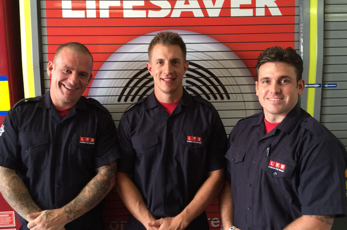 Three of the Firefighters that helped deliver the baby stood in front of a fire engine