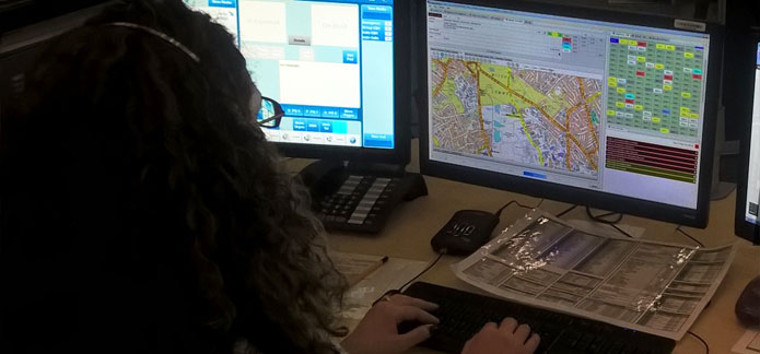 Member of LFB staff with their back to the camera working on a computer, the screen has a map on it