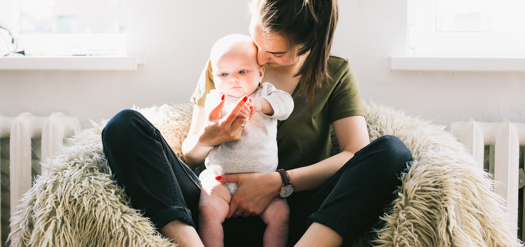 Mother holding a baby while sitting on a bean bag