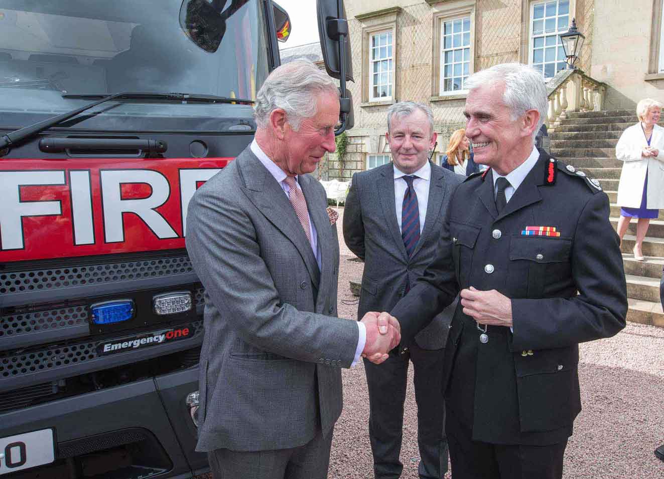 Prince Charles handshake in front of a Fire Engine