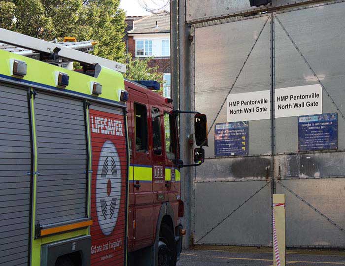 Side view of a fire engine as it pulls up the gates of Pentonville prison