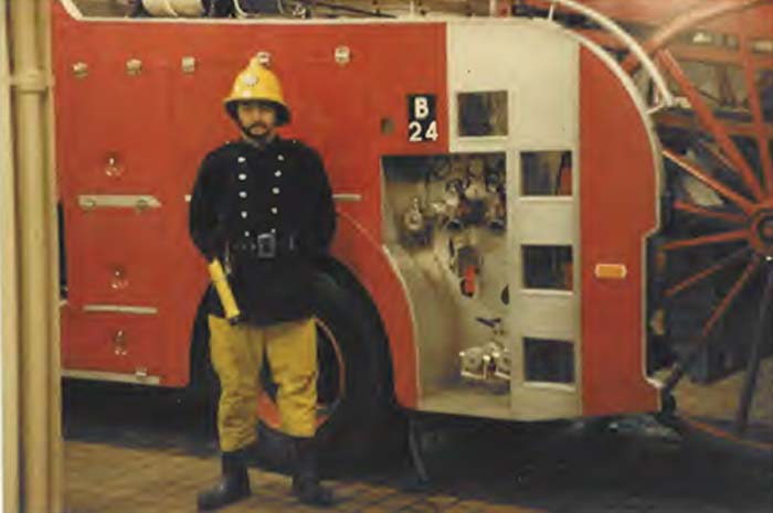 Steve Brooker in front of a Fire Engine wearing his uniform