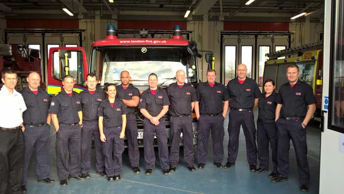 Firefighters standing in front of a fire engine 