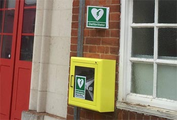 Yellow Defibrillator box on the wall outside Plumstead fire station