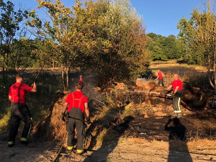 Firefighters tackling a grass fire.