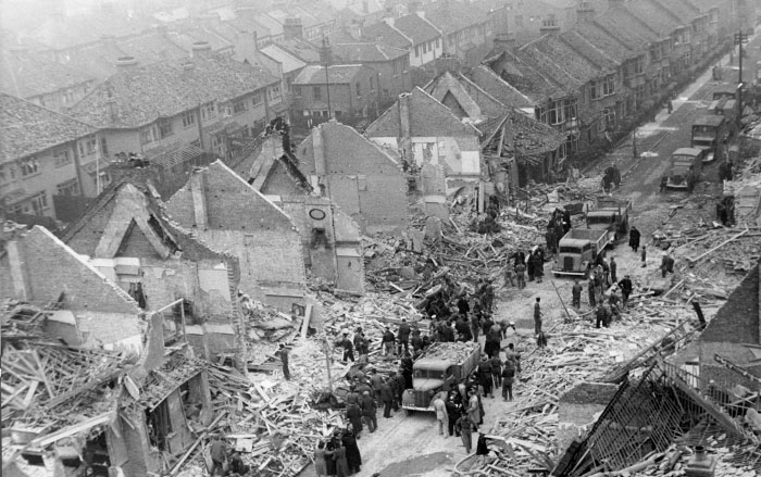 Firefighters on a street in the rubble of a Blitz raid