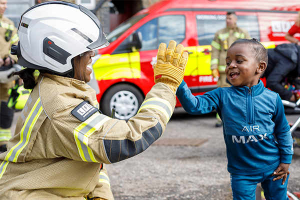 A firefighter and a child at an open day