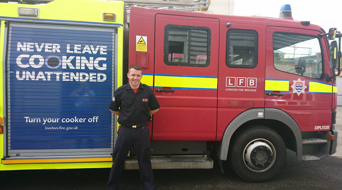 Firefighter Ian Tobin standing in front of a fire engine