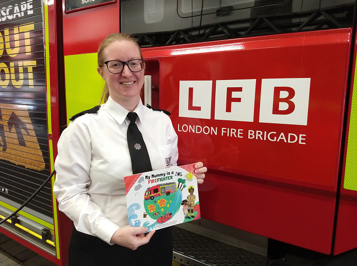 Lynsey Seal holding the book 'My Mummy is a Firefighter'