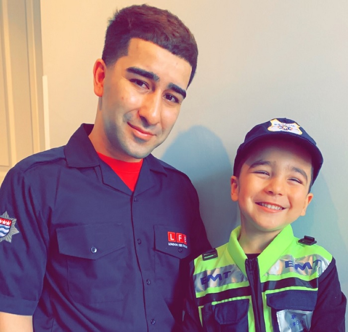 Firefighter Uzair Yaqoob and his son, who is dressed as an ambulance crew member