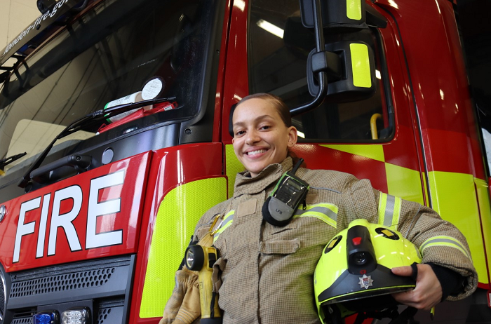 Tiarna-Ann Pearce holding her helmet in front of a fire engine