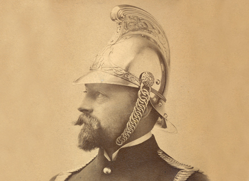 Sepia portrait of a firefighter wearing a brass helmet.