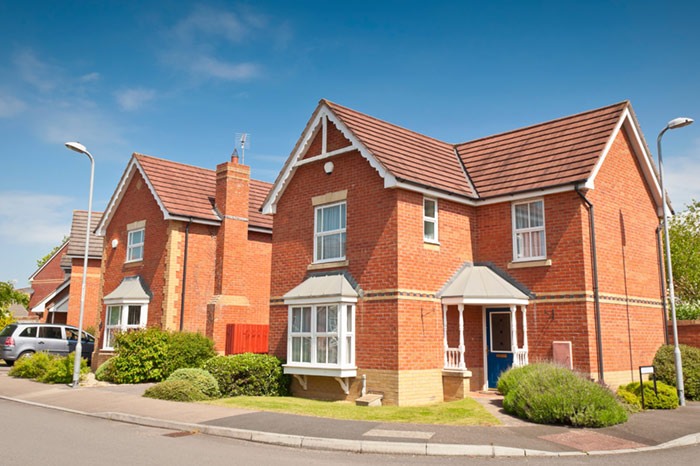 Housing with lawn and plants as well as room for a car