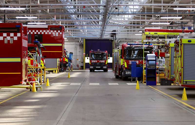 Interior view of the LFB workshop in Ruislip, showing several fire brigade vehicles being serviced. Likely taken around 2023.