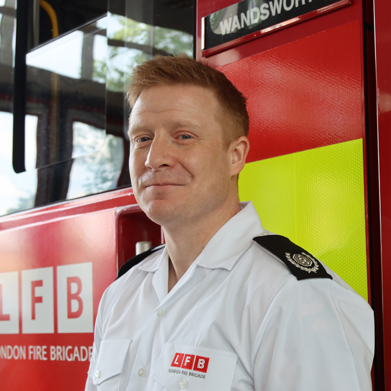 Borough Commander Grant Bishop standing in front of a fire engine.