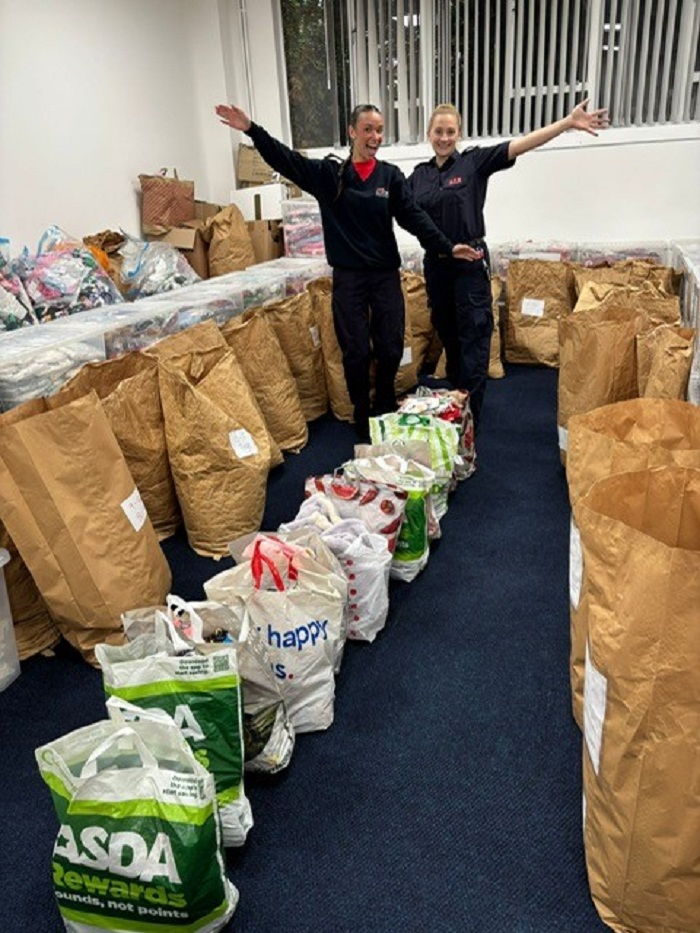 Two firefighters pose with donated pyjamas