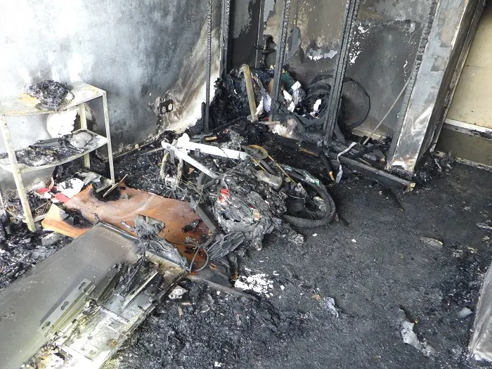A badly burnt room with a e-bike in the middle